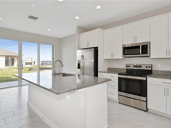 Bright kitchen with island and stainless-steel appliances
