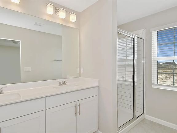 Bathroom with dual vanity and glass shower